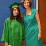 Graduate in regalia with woman in green dress