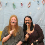 two women with fake mustaches for photo booth