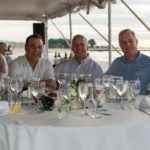 Five men seated at a table with many glasses smile at the 2013 Howard F. Treiber Memorial Golf Outing