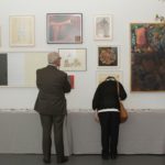 two people looking at hanging art