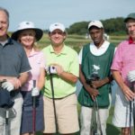Five individuals stand in golf caps and holding golf clubs smiling at the 2013 Howard F. Treiber Memorial Golf Outing