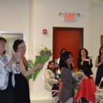women applauding and giving bouquets
